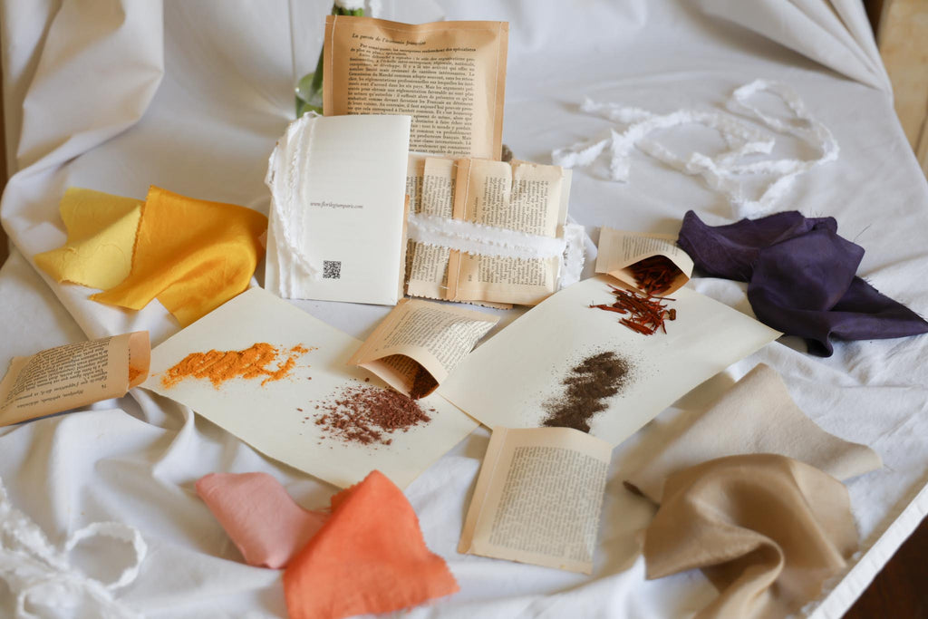 Florilegium Paris natural dye kit — plant-based pigments and naturally dyed fabric swatches in multiple colors — handmade packaging from vintage book pages