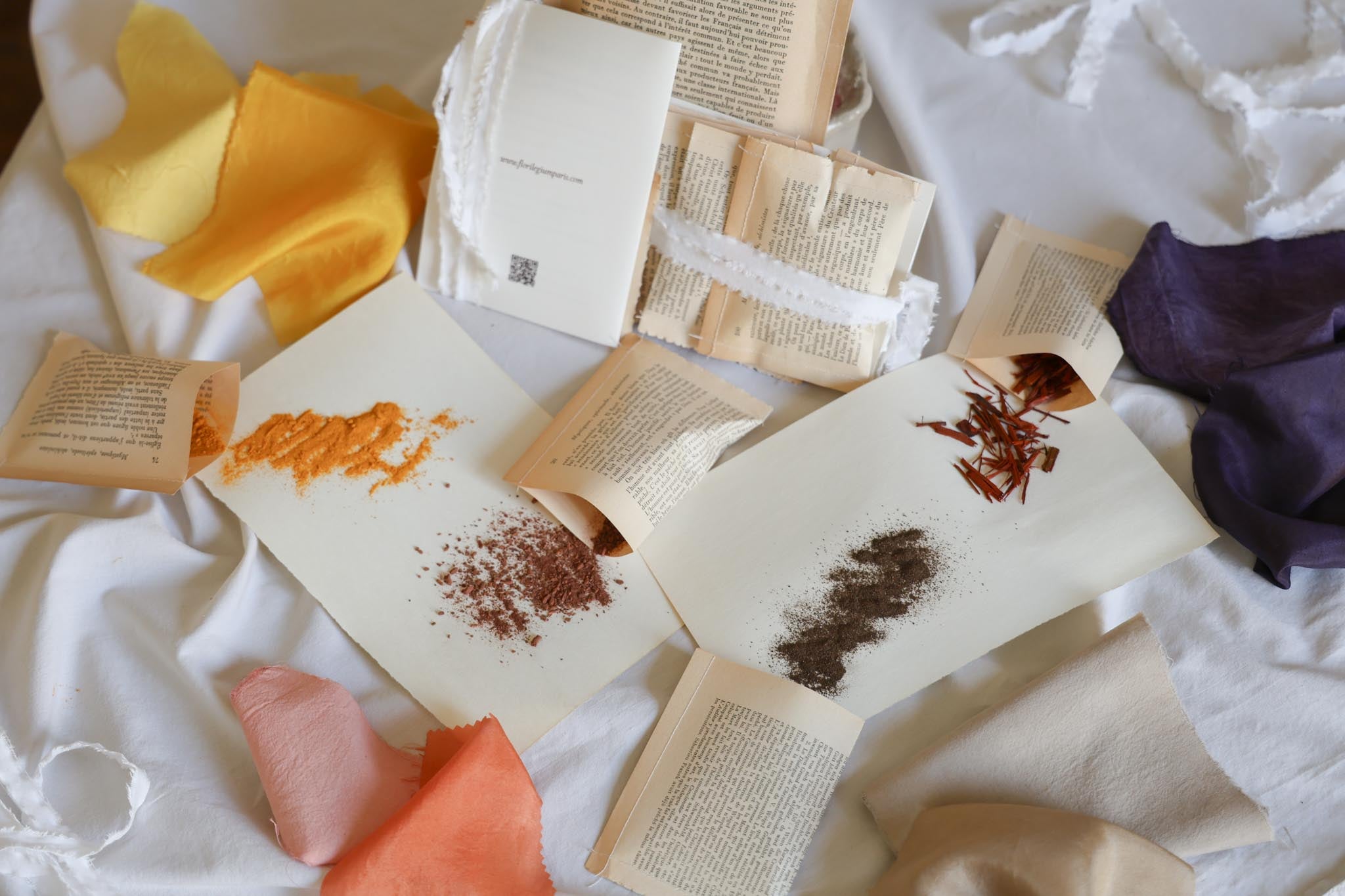 Florilegium Paris natural dye kit — plant-based pigments and naturally dyed fabric swatches in multiple colors — handmade packaging from vintage book pages