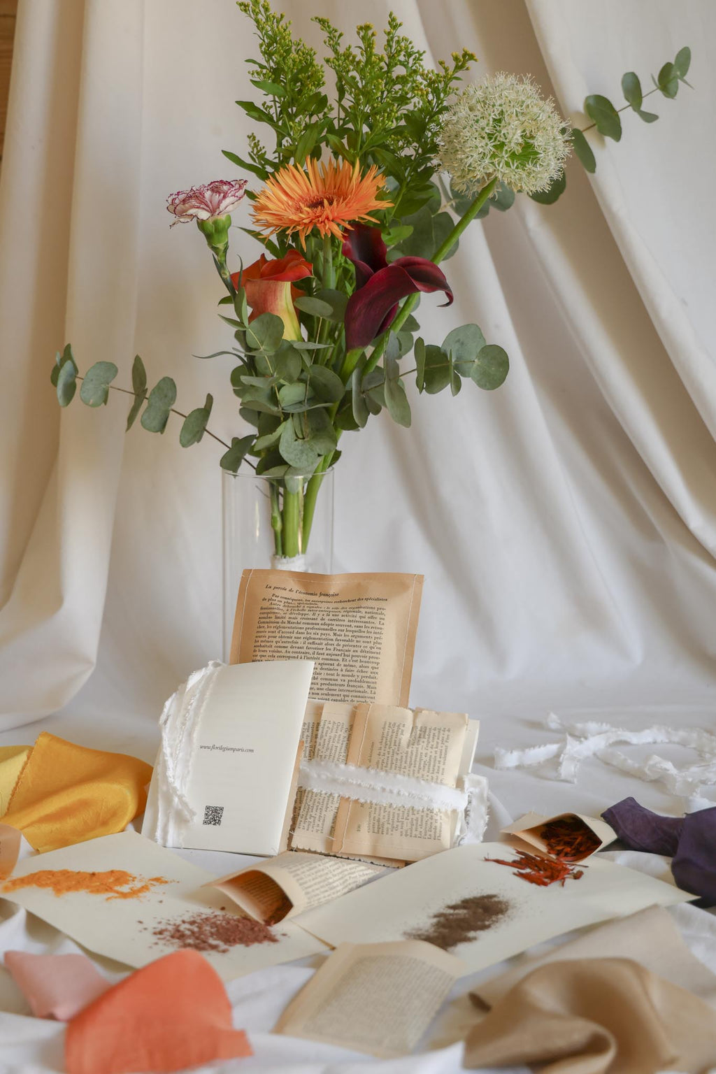 Florilegium Paris natural dye kit — plant-based pigments and naturally dyed fabric swatches in multiple colors — handmade packaging from vintage book pages